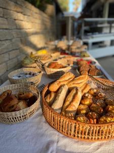 uma mesa coberta com cestas de pão e pastelaria em La Bastide des Salins em Saint-Tropez