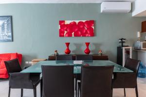 una mesa de comedor con sillas y una pintura de manzanas rojas en Meridian 207 condo, en Playa del Carmen