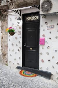 a black door on the side of a house at [Via Dei Tribunali–Duomo] Casina in Centro Storico in Naples
