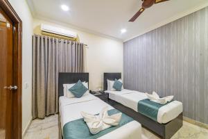 a bedroom with two beds and a window at Luxury Suites by Athome in Kondapur