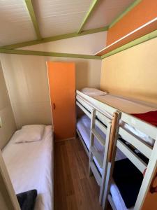 a small room with two bunk beds in it at Le Camping de la Plage in Aregno