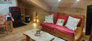 a living room with a red couch and a table at Appartement style montagne avec SPA in Égat