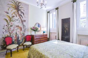 1 Schlafzimmer mit einem Bett, 2 Stühlen und einer Kommode in der Unterkunft Ca' Margherita Secret Garden in Venedig