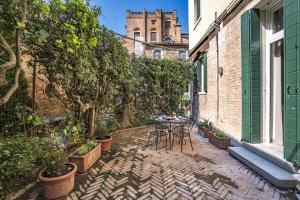 eine Terrasse mit einem Tisch und Stühlen sowie ein Gebäude in der Unterkunft Ca' Margherita Secret Garden in Venedig