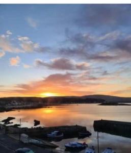a sunset over a harbor with boats in the water at Wee Cumbrae View in Millport