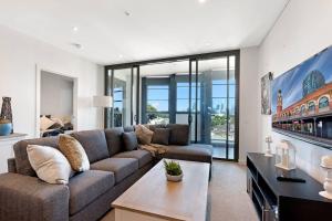 ein Wohnzimmer mit einem Sofa und einem Tisch in der Unterkunft Location Style Comfort and Beauty on Swan in Melbourne