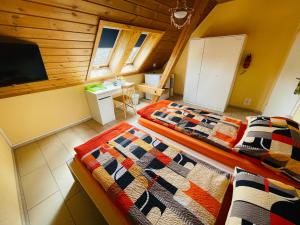 two beds in a small room with a television at Bed-International in Roggwil