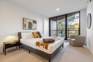 ein Schlafzimmer mit einem großen Bett und einem Stuhl in der Unterkunft Walk to the Grand Prix track - Albert Park in Melbourne