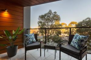 eine Veranda mit zwei Stühlen und einer Topfpflanze in der Unterkunft Walk to the Grand Prix track - Albert Park in Melbourne