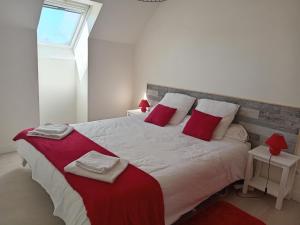 een slaapkamer met een groot bed met rode en witte kussens bij Sérénité à la mer in Concarneau