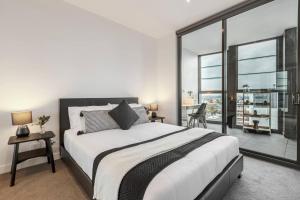 a bedroom with a large bed and a large window at Lovely 1-bedroom apartment - 0177 in Melbourne