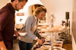 Um homem e uma mulher numa cozinha a preparar comida. em Hotel Hanswirt em Rabla