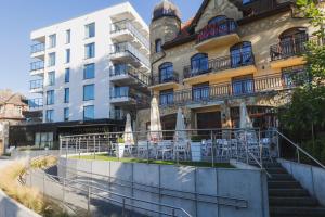 a building with tables and chairs in front of it at Trofana Wellness & SPA in Międzyzdroje