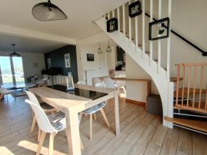een eetkamer en een woonkamer met een tafel en een trap bij Sérénité à la mer in Concarneau