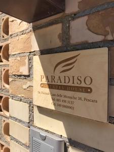a sign for a parallax company house on a brick wall at Paradiso Country House in Pescara