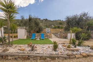 Diano San Pietro的住宿－Veggia Butega，花园设有2把蓝色椅子和桌子,种有树木