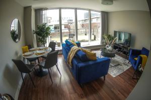 a living room with a blue couch and a table and chairs at Charming Duplex in Grand Canal in Dublin