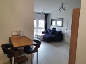 ein Wohnzimmer mit einem Tisch und einem blauen Sofa in der Unterkunft Apartament Business Sienkiewicza in Leszno
