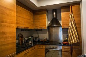a kitchen with wooden cabinets and a stove top oven at Charming Duplex in Grand Canal in Dublin