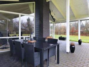 a black table and chairs on a patio at 6 person holiday home in H jslev in Højslev
