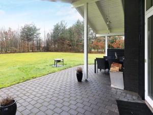 a patio with a table and a piano on a house at 6 person holiday home in H jslev in Højslev