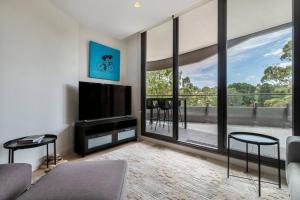 a living room with a tv and a large window at Peaceful 2 bedroom unit with Free parking in Melbourne