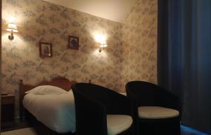 a bedroom with a bed and a chair at Logis Auberge le centre poitou in Coulombiers