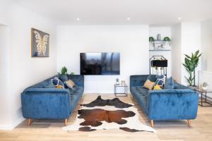 a living room with two blue couches and a rug at Amazing New Spacious Apartment in SE1 in London