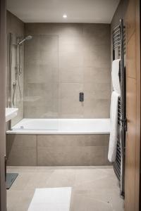 a bathroom with a bath tub and a shower at Amazing New Spacious Apartment in SE1 in London
