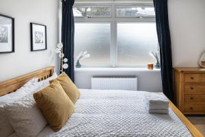 a bedroom with a bed with a large window at Amazing New Spacious Apartment in SE1 in London