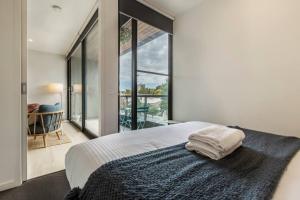 1 dormitorio con cama y ventana grande en Walk to the Grand Prix Track 01583, en Melbourne
