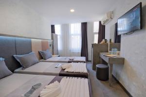 a hotel room with two beds and a tv at The Queen Hotel in Istanbul