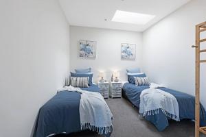 墨爾本的住宿－The Hamptons on Swan 00220，配有两张床铺的蓝色毯子和枕头