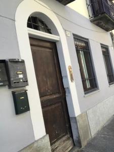 une porte marron sur un bâtiment avec une fenêtre dans l'établissement Nicoletta House, à Moncalieri