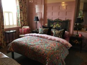 a bedroom with a large bed with a colorful blanket at The Forester and Flower in Bath