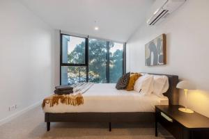 a bedroom with a bed and a large window at Lovely 2-bedroom with free parking - 03224 in Melbourne