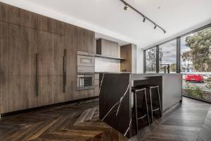 a kitchen with wooden cabinets and a black counter top at Lovely 2-bedroom with free parking - 03224 in Melbourne