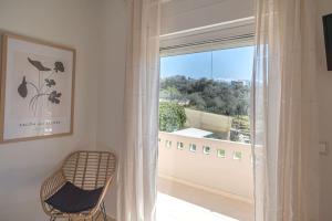 een stoel naast een raam in een kamer bij Summer Blue Apartments Chania in Chania