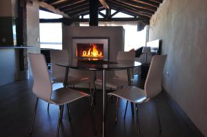 comedor con mesa, sillas y chimenea en Suite rural con jacuzzi, en Cabañas de Polendos