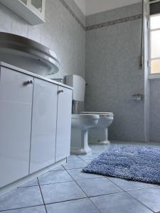 uma casa de banho com um lavatório, um WC e um tapete em Cà del Fili em Lenno