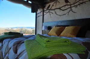1 dormitorio con 1 cama con toallas verdes en Suite rural con jacuzzi, en Cabañas de Polendos