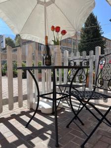 a table with an umbrella and a vase with flowers at Cà del Fili in Lenno