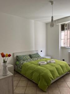 una camera da letto con un letto verde e asciugamani di Cà del Fili a Lenno