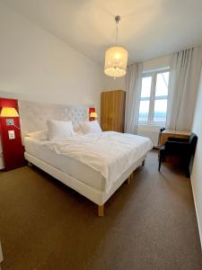 Un dormitorio con una gran cama blanca y una lámpara de araña. en Holiday home Prague, en Praga