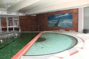 弗瓦迪斯瓦沃沃的住宿－Apartament Patio 50 m od plaży，一座大型游泳池,位于一座建筑中,拥有绿色的海水