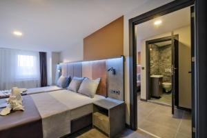a bedroom with a large bed and a bathroom at The Queen Hotel in Istanbul