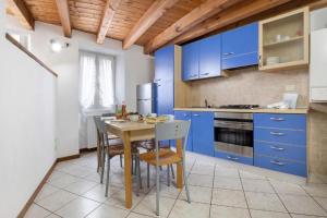 een keuken met blauwe kasten en een tafel en stoelen bij Francesco in Gargnano