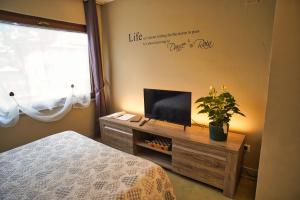 - une chambre avec un lit et une télévision à écran plat dans l'établissement Vanda Luxury House near Gardaland and Garda Lake, à Castelnuovo del Garda
