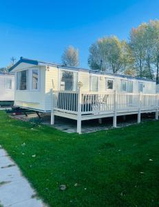 a mobile home with a porch and a deck at Charming 6 birth caravan in skegness in Skegness