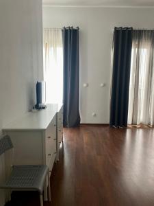 an empty room with a desk with a computer and blue curtains at Platan 17 in Świnoujście